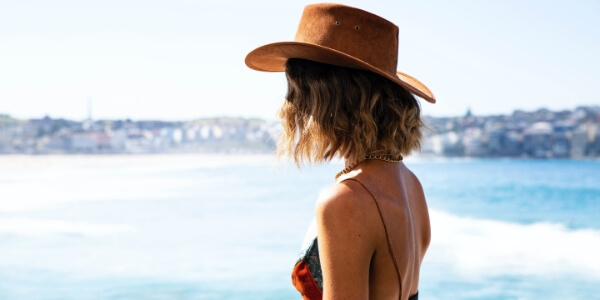 A woman standing outside on a beach.