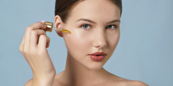 A woman applying oils to her face.